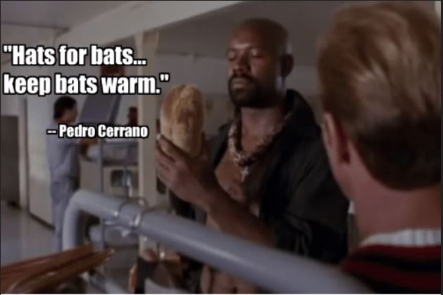 Still from “Major League” where Pedro Cerrano is putting a golf club cozy on his hat, and says “Hats for bats … keep bats warm.”